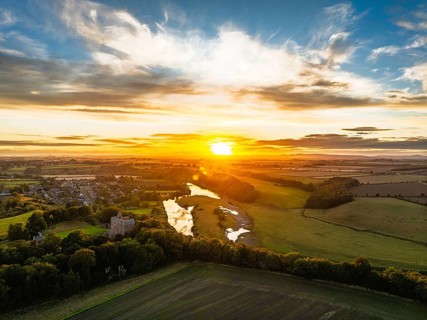 Sunset over Norham Castle and River Tweed from a drone, Norham, Northumberland, England, United