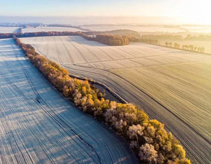Bird Eye Perspective of Frost Covered Farmland. Seasonal Agricultural Scenery, winter and autumn