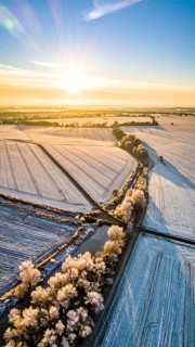 Bird Eye Perspective of Frost Covered Farmland. Seasonal Agricultural Scenery, winter and autumn