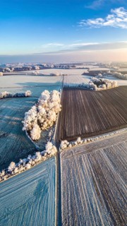 Bird Eye Perspective of Frost Covered Farmland. Seasonal Agricultural Scenery, winter and autumn