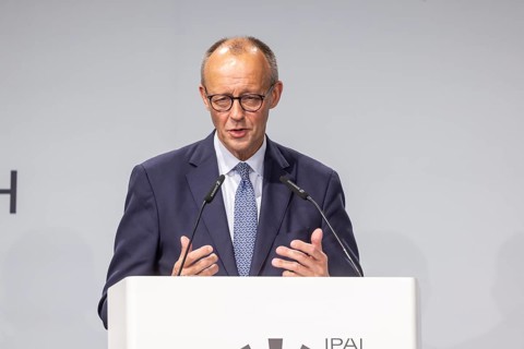 Federal Chancellor Friedrich Merz (CDU) . Portrait at the lectern with free text space.