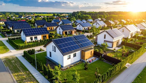 Aerial view showcases modern houses with solar panels and green roofs in a suburban setting,