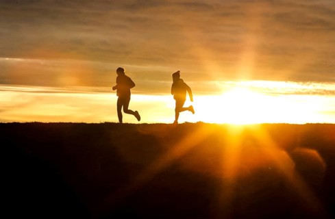 Woman and child walk across a dike on the island of Fehmarn at sunset, 13.10.2025, Fehmarn,