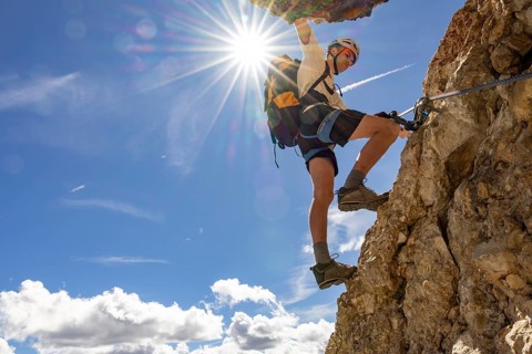 Mountaineer climbs on Ferrata Furcela de Saslonch, Langkofelscharte via ferrata, Dolomites,