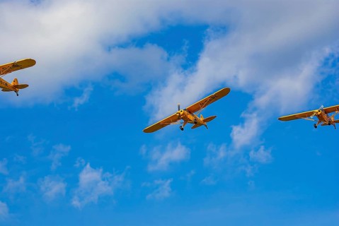 Three Piper PA-18 Super Cub aeroplanes of the Bravo Lima Formation flying in formation during an