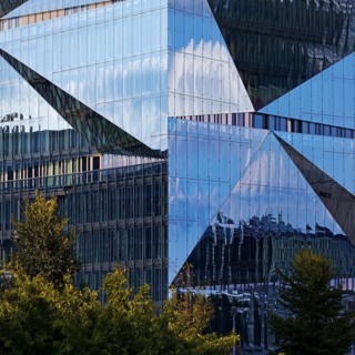Cube Berlin, cube-shaped office building with folded glass façade reflecting the surroundings,