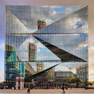 Cube Berlin, cube-shaped office building with inwardly folded glass façade reflecting the