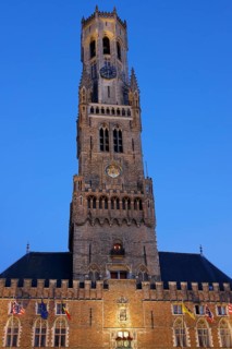 Illuminated Belfry in the historic city centre of Bruges in the evening light, Belfort and City