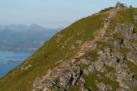 Woman with hiking poles walking up Rørsethornet stone stairs, with 3292 steps one of the longest