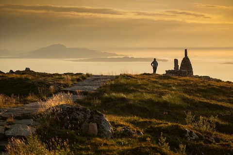Woman standing next to cairn and looking at the sea, Rørsethornet stone staircase, with 3292 steps