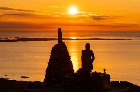 Silhouette of a woman watching the sunset next to cairns, Rørsethornet stone staircase, with 3292
