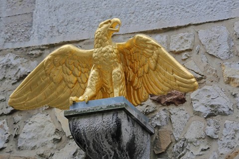 Golden eagle figure with outstretched wings above the entrance to the Kupferhof Schleicher, gilded