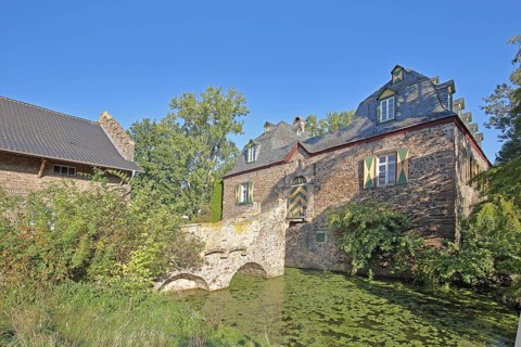 Manor house with stone arch bridge in the inner courtyard of the Kleeburg castle built in the 14th