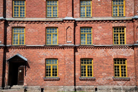 Brick façade with yellow windows, former paper factory and mill for the production of groundwood