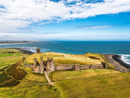Dunstanburgh Castle from a drone, Northumberland Coast, England, United Kingdom