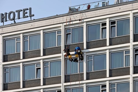 Two male glass cleaners abseiling down the hotel façade to clean windows, aletto Hotel Kudamm,