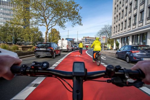 Riding a bike in a bike lane, marked in red to attract the attention of motorists, between 2 lanes,