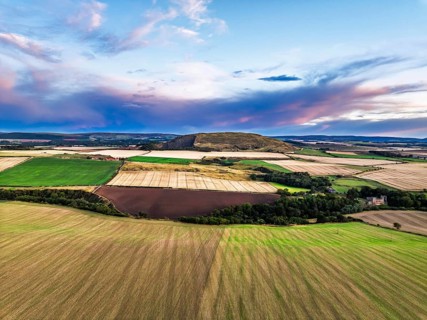 Sunset of Fields and Farms over Traprain Law and Hailes Castle from a drone, River Tyne,