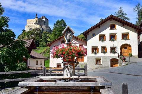 Village fountain in Tarasp, municipality of Scuol, in the background Tarasp Castle in the Lower