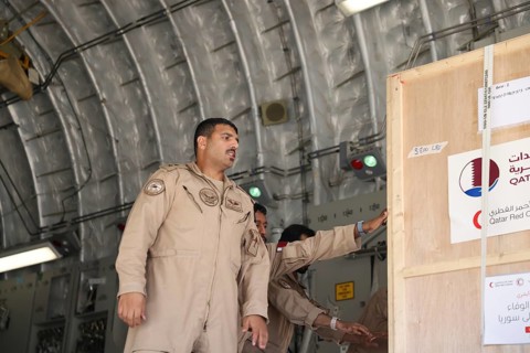 Members of the Qatari Air Force unload humanitarian aid supplies from a transport aircraft at