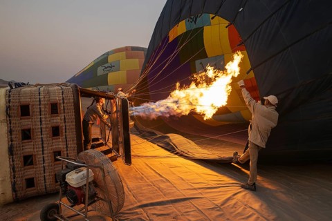 In order to get ready for the take-off, the pilot inflates the balloon with hot air by activating