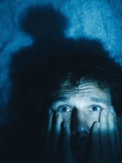 A close-up of a man whose face is marked by fear, symbolising anxiety disorders, panic attacks,