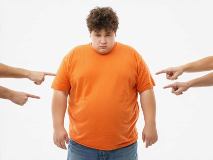 Overweight boy being judged by pointing fingers, symbolising fatshaming, bullying, judgement and