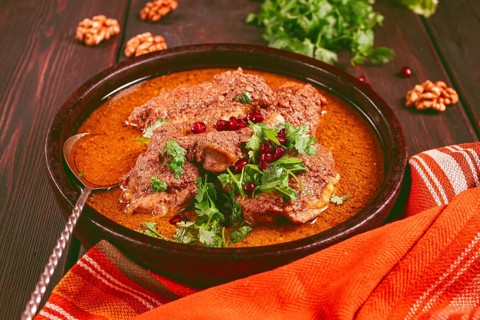 Fesenjan, an Iranian dish, stewed chicken, in walnut-pomegranate sauce, in an earthen pan,