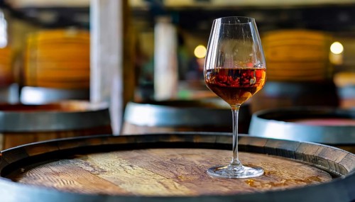 Glass of 10-year-old tawny wine placed on a barrel in a vineyard restaurant, AI generated