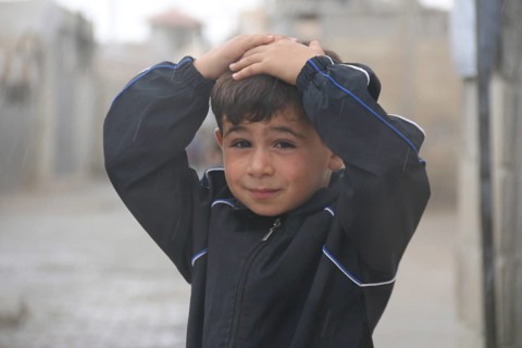 A Syrian refugee child photographed in a camp, reflecting the harsh living conditions of displaced