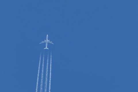 Airbus A340-300 jet aircraft of Lufthansa airlines in flight in a blue sky with vapour trails or
