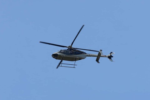 Bell 407GXP jet ranger helicopter flying in a blue sky, England, United Kingdom