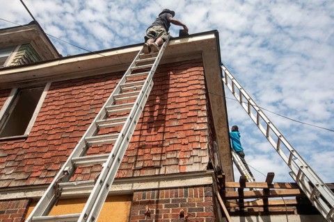Detroit, Michigan - Workers re-roof a house they are remodeling in the Morningside neighborhood