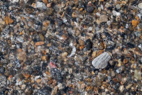 Colourful, smooth pebbles under a clear water surface, North Sea, Denmark
