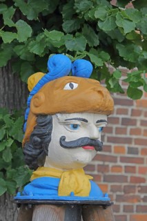 Colourful Swedish head as a landmark, historic wooden head with face and four eyes, tree house, Old