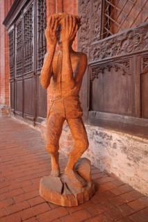 Wooden figure with hands in front of the face, interior view, wooden sculpture, modern art, wood