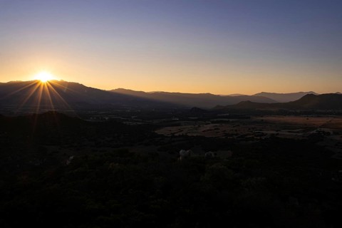 The sun sets behind the mountains on the Mediterranean island of Sardinia, Monte Nai, Costa Rei,