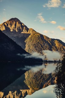 Sunrise with reflections and alpenglow in Lake Heiterwanger See in Tyrol in the Alps in Austria