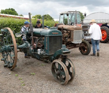People viewing vintage Fordson tractors on display at auction, UK