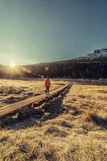 Young woman at Lake Staz near Sankt Moritz in the Engadine in Switzerland. Morning atmosphere with
