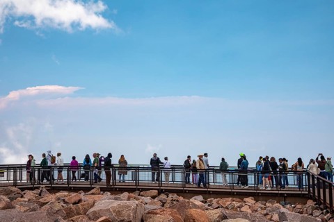 Colorado Springs, Colorado - Tourists line a viewing plantform at the summit of Pikes Peak, a 14,