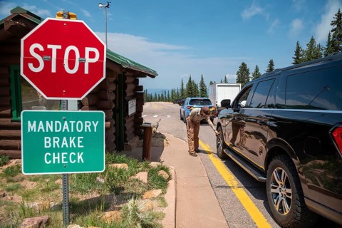 Colorado Springs, Colorado - A Pikes Peak ranger checks the temperature of brakes on a car