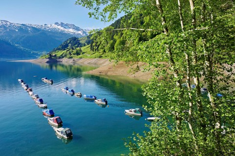 Motorboats moored at the reservoir, snow-covered Alps in the background, Lake Wägital, Canton