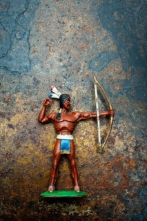 A bright plastic toy archer stands poised with his bow drawn back, showcasing the figure of an