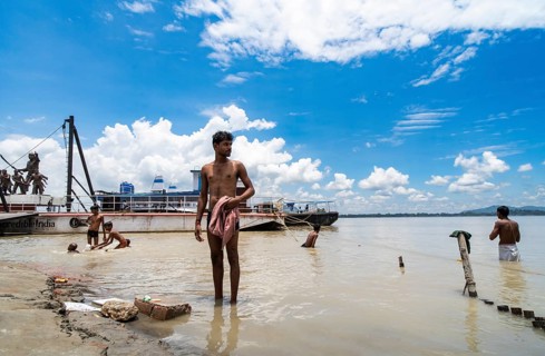 People bathe in the Brahmaputra River to seek relief from the intense summer heat in Guwahati,