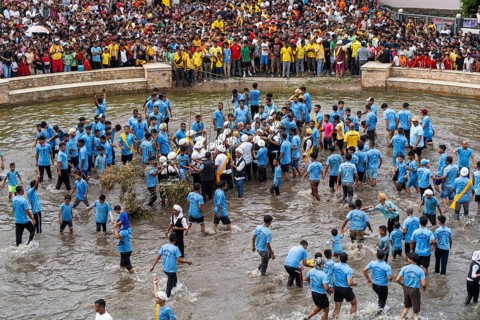 People from the Pnar community perform rituals as they using a tree to celebrate an event organised