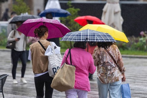 Rainy weather in Stuttgart. People with umbrellas hurry through the rain on Königstraße. Stuttgart,
