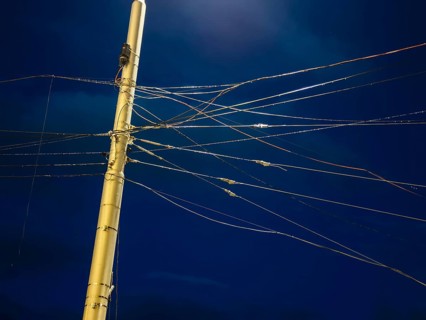 Night shot of many cables and wires for overhead lines on a lamppost in Bratislava, Slovakia