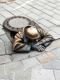 Gaffer (Cumil), bronze sculpture of a worker looking out of a manhole in Bratislava, Slovakia