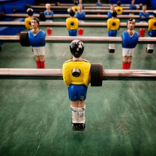 In a vibrant recreation space, a vintage table football game features colorful player figurines